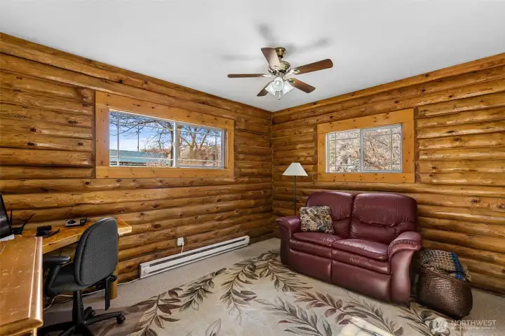 Study or Guest Bedroom -  Ideal as a home office, study, or additional bedroom, this light-filled space offers peaceful views and classic log walls—perfect for remote work or welcoming overnight guests.