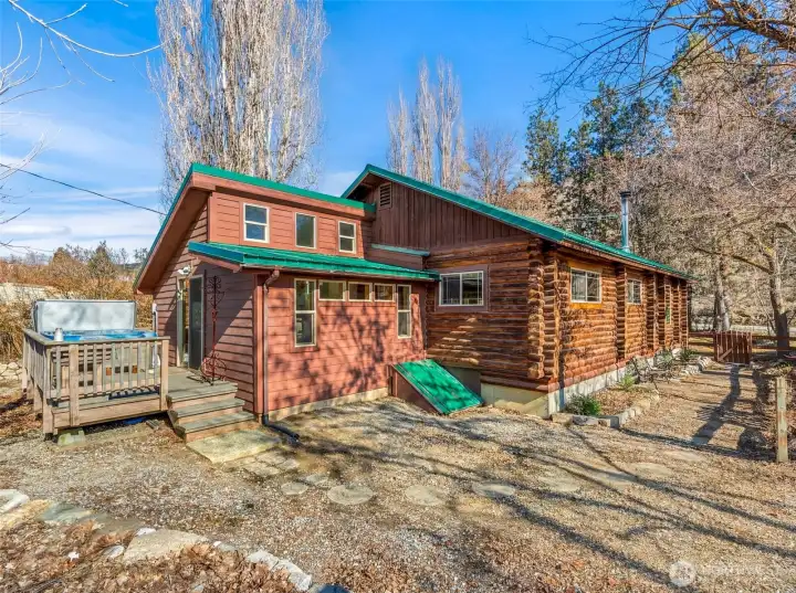Exterior – Daylight  Charming log home with metal roof and inviting deck, blending rustic character with modern updates — private, peaceful, and just minutes from Lake Chelan recreation.
