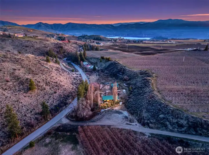Aerial at Sunset -  Sweeping aerial views capture the property’s unique setting near orchards, rolling hills, and Lake Chelan—offering both seclusion and proximity to recreation.