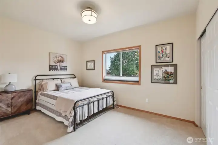 Comfortable guest bedroom with ample natural light.