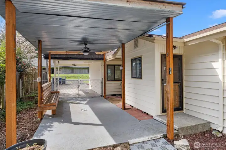 Covered patio with ceiling fan and built in bench.