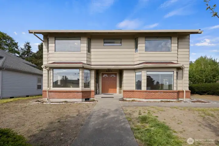 Daytime front view with a centered entry, clean lines, and a walkway leading up to the front door