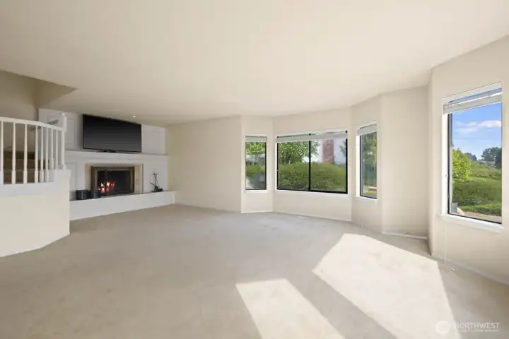 Open living space with multiple windows bringing in natural light and views of the surrounding exterior