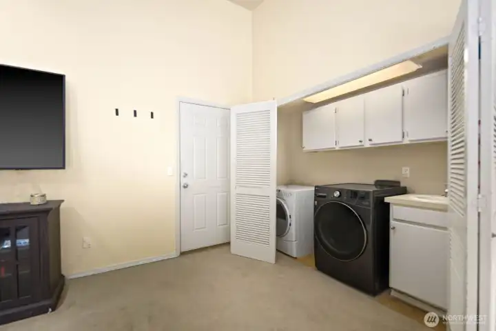 Laundry area with upper cabinetry, utility sink, and washer and dryer connections
