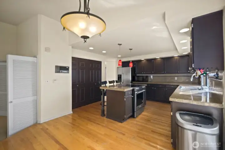 Kitchen with central island, bar seating, and wraparound cabinetry for storage and workspace