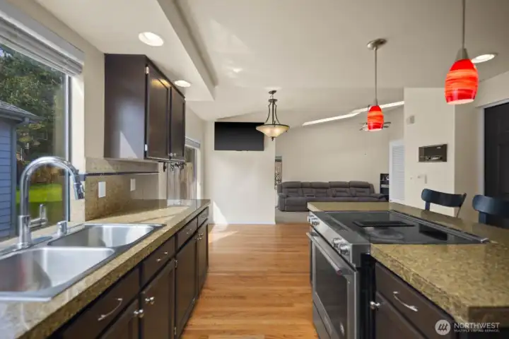 Kitchen and dining area with island seating, pendant lighting, and sliding door access to the backyard
