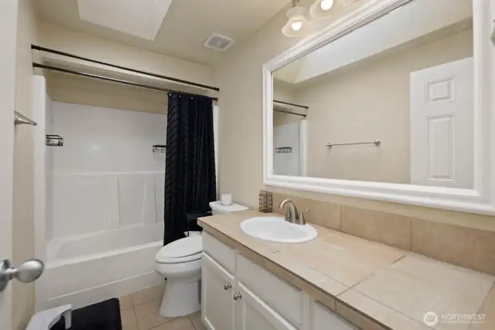 Full bathroom with tub/shower combination and single vanity.