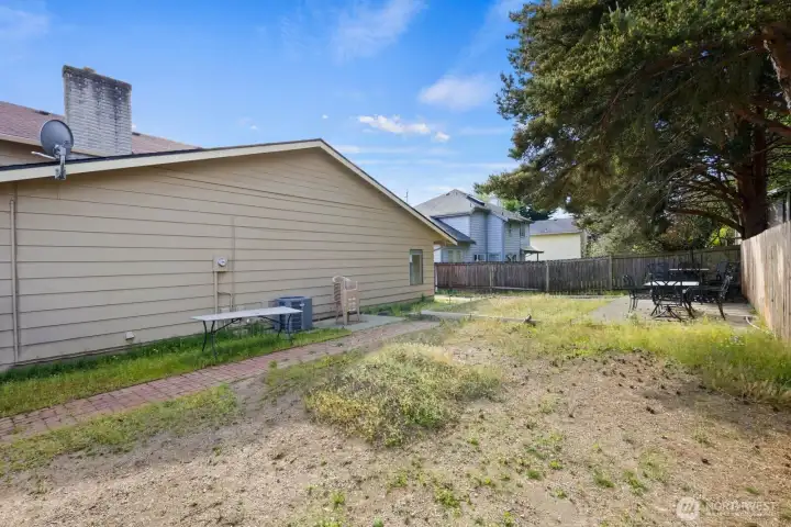 Backyard with fenced perimeter, patio area, and open space for outdoor use.