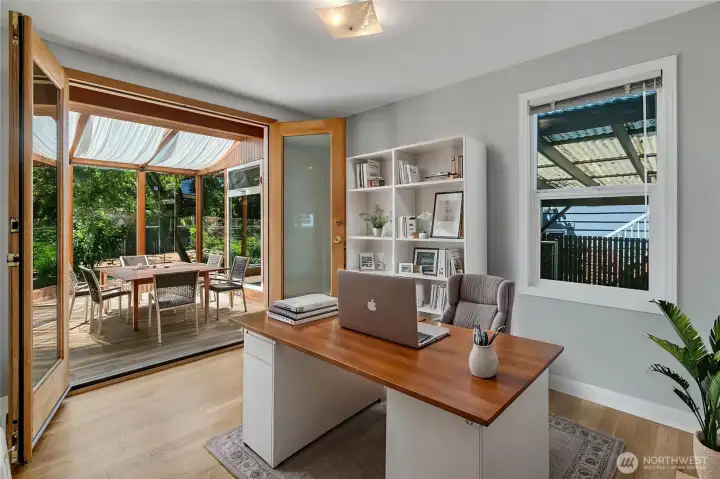 Virtually staged main floor office opening to sunroom.