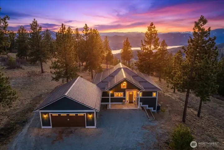 Drone twilight photo of home overlooking lake and butte