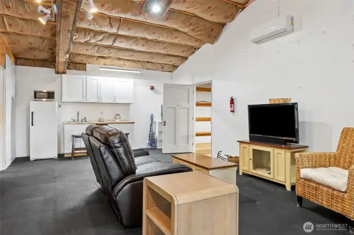 This unfinished apartment above the shop has the kind of upside potential that gets buyers immediately spinning out into future plans before they have even left the property. The vaulted ceilings give the space a surprisingly open & inviting feel, & much of the foundational work has already been started including THREE separate mini-split systems for heating & air conditioning plus a kitchenette setup featuring white shaker cabinetry. The refrigerator & microwave remain w/the property as well, creating a fantastic starting point for finishing the space into guest quarters, a private office retreat, creative studio, caretaker setup or add'l living area depending on future needs. What makes it especially appealing is how separate it feels from the main home while still sitting fully integrated into the overall compound-style layout of the property. This is the kind of flexible bonus space that becomes more valuable the longer you own it b/c life inevitably invents uses for it over time.