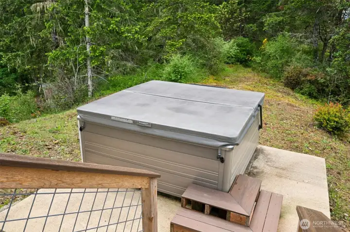 This dedicated hot tub area adds another layer of retreat-style living to the property because the setting out here feels incredibly peaceful and private surrounded by towering trees, territorial views and the quiet natural atmosphere that comes with living atop 20 acres. The concrete pad already includes the necessary hookups for a hot tub setup, and while the current hot tub included with the property needs some repair, it also comes with the cover and convenient access steps that can easily work with a future upgraded unit if desired. The location itself is honestly fantastic because you still capture the same beautiful natural scenery and expansive outlooks found throughout the rest of the property while feeling tucked into your own little forest spa hideaway at the same time. This is exactly the kind of spot that turns into everyone’s favorite place on the property after sunset.