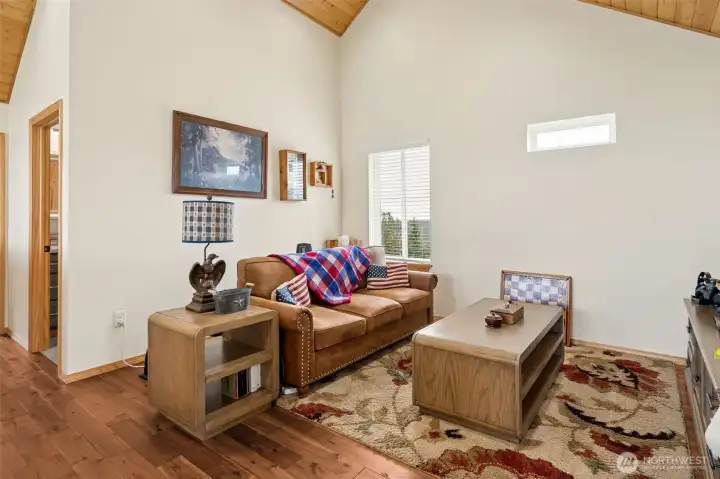 Upstairs, this vaulted family room creates such a fantastic flexible bonus space and feels wonderfully tucked away from the main living areas while still staying visually connected to the warm mountain-home character throughout the house. At approximately 13.5 x 18 feet, there is plenty of room here for a media lounge, reading retreat, game room, office setup or secondary hangout space depending on how life unfolds, and the vaulted ceilings paired with the gorgeous wood plank ceiling detail keep the room feeling airy and architecturally interesting. Hardwood flooring replaces the slate upstairs adding warmth and softness underfoot while beautifully complementing the rich wood tones overhead, and the thoughtfully placed upper window allows natural light to flood the room without sacrificing furniture placement flexibility. Cozy, functional and full of personality, this room feels like the perfect upper-level escape space.