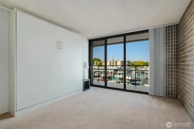 Bedroom, with a sliding glass door leading to the private balcony. Newer Murphy Bed was installed to save space.  It can be removed if a buyer does not want it.