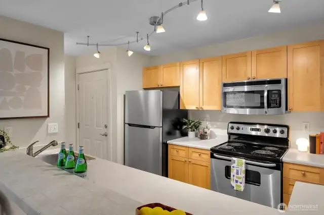 Stainless-steel appliances complement warm wood cabinets.