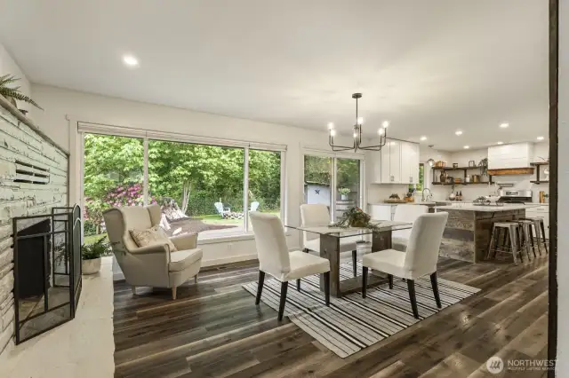 Rich hardwood flooring enhances the open-concept kitchen and dining area