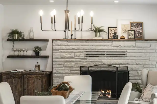 Charming wood fireplace creates a welcoming ambiance in the open dining and kitchen space.