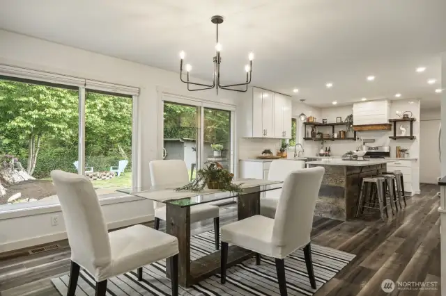 Seamless flow between kitchen and dining, featuring modern lighting and plenty of windows for natural light.