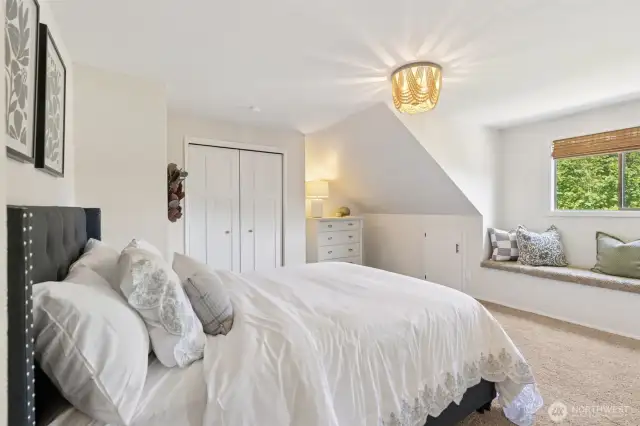 Inviting upstairs bedroom features a built-in window bench & a stylish beaded chandelier—bringing warmth, character & a polished designer touch to the space