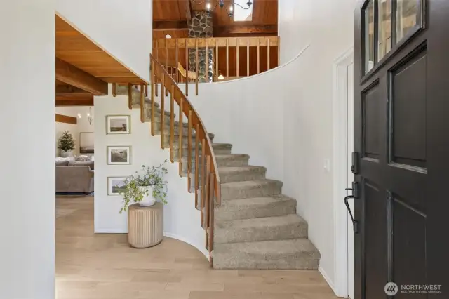 Grand entry greets you w/ a sweeping curved staircase & open 2nd-floor banisters—setting the tone for style, space & sophistication throughout the home