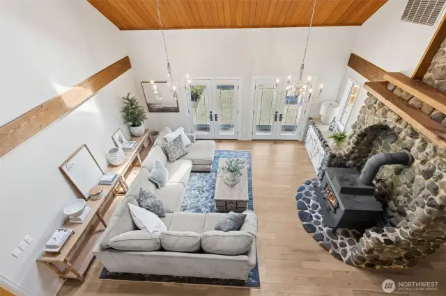 View from the catwalk highlights the soaring great room & showcases the stunning floor-to-ceiling river rock fireplace—a dramatic focal point anchoring the home's open design