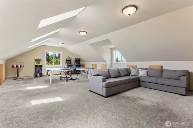 This oversized bonus room is the ultimate hangout—set up for games, lounging & fun, w/ built-in storage, a full closet, skylights & windows that keep the energy bright & inviting
