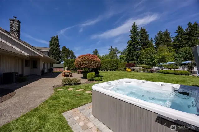 Relax in the inviting hot tub while taking in serene views of the landscaped yard—an ideal spot to unwind, connect, or enjoy quiet moments surrounded by nature and open space