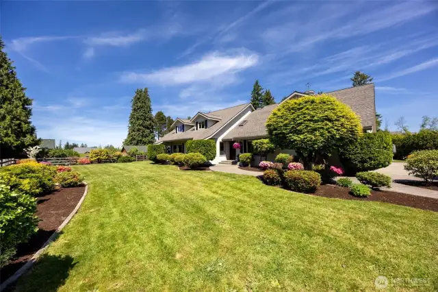 Lush front yard offers wide-open grassy space—perfect for play, relaxing, or simply enjoying the serene surroundings and natural beauty of the property’s setting
