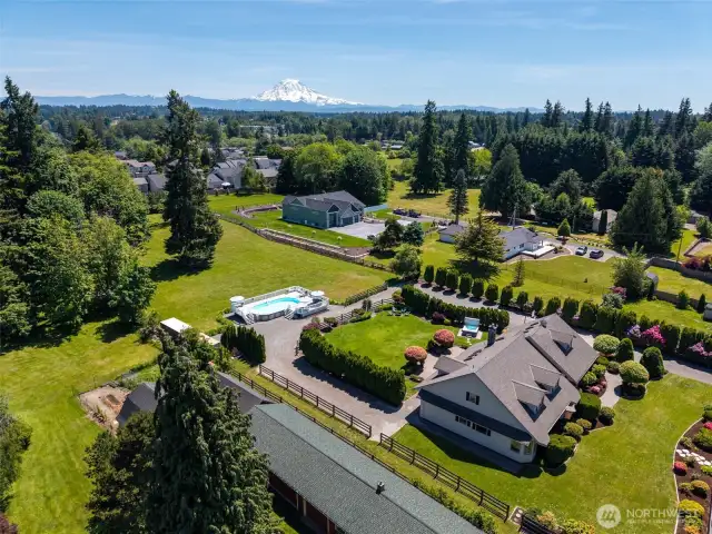 Side view of the home captures its impressive scale & architecture—set against the stunning backdrop of Mt. Rainier, blending natural beauty with timeless design