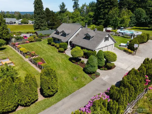 Driveway leads to a spacious 3-car garage & features a basketball hoop—perfect for extra parking, storage, & outdoor fun the whole household can enjoy