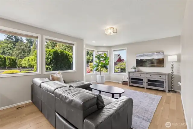Just steps from the kitchen, the living room invites you in w/ oversized windows framing peaceful views of the private garden—bringing the outdoors in with warmth & light