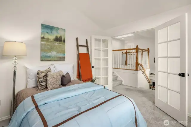 Off the staircase between the main and upper level are French doors that open up to a flex room with a closet. This room could be a den or potential 5th upstairs bedroom which is how it is currently staged.