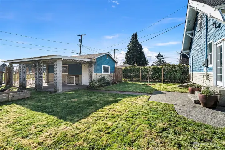 An enclosed dog run/chicken coop or just more garden space with a separate fence and gate to the side of the garage.