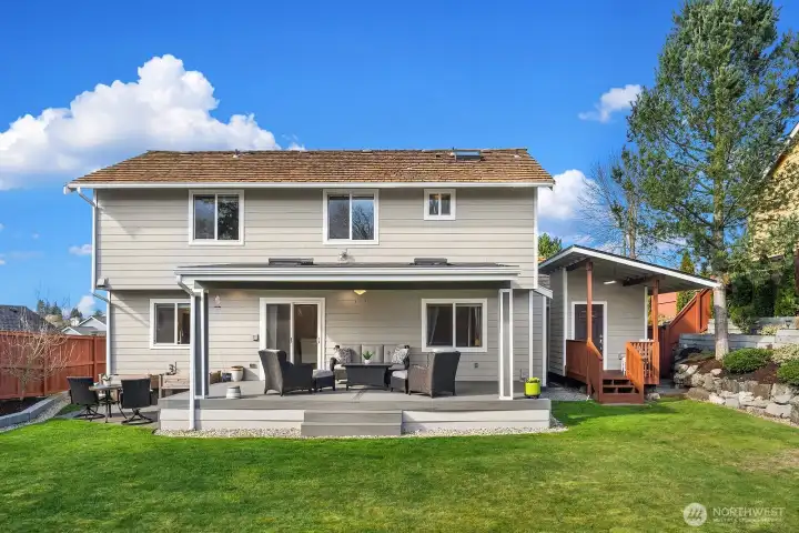 Photo of backyard showing covered deck and small outbuilding.