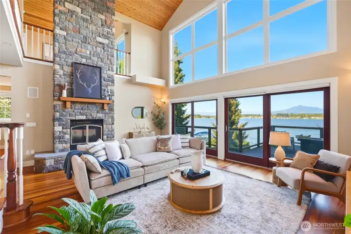 Breathtaking main living room with brazilian cherry floors, floor-to-ceiling, double-sided fireplace, floor-to-ceiling windows, vaulted cedar ceilings and sliders to the expansive deck.