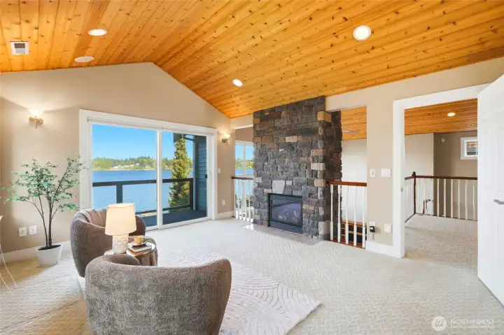 Through the french doors is the private sitting room with vaulted cedar ceilings, fireplace and private deck overlooking the lake.