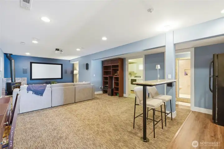 Walk-out basement features an 82" projection screen, freestanding gas fireplace, built-ins & a kitchenette!