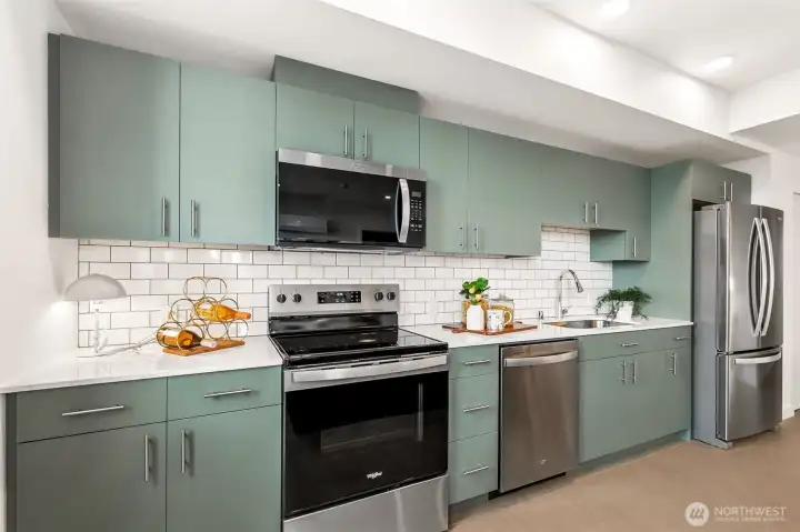 Stylish all electric kitchen featuring modern cabinetry and subway tiled backsplash Stylish all electric kitchen featuring modern cabinetry and subway tiled backsplash