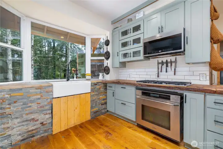 Farmhouse sink framed by woodland views, bringing the outdoors into the heart of the home.