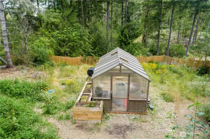 The greenhouse extends the growing season, making it easy to nurture seedlings, vegetables, herbs, and flowers year-round.