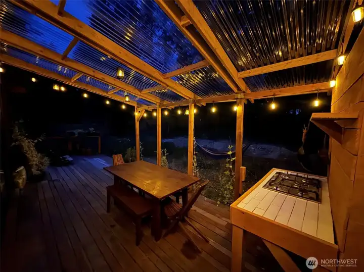 The covered outdoor kitchen creates a warm gathering space long after sunset.
