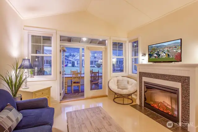 Great room has vaulted ceilings and electric fireplace.