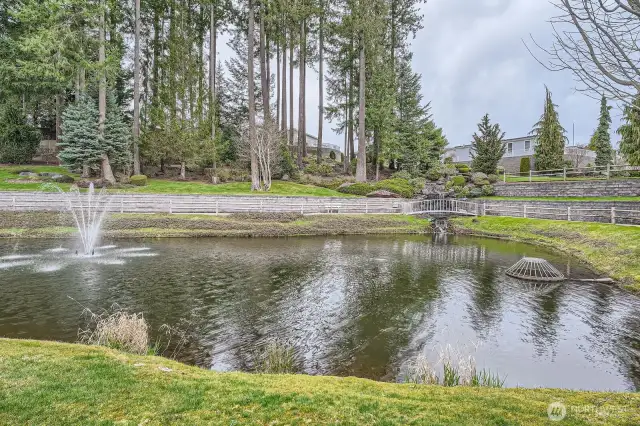 The community features a serene pond surrounded by a walking path.
