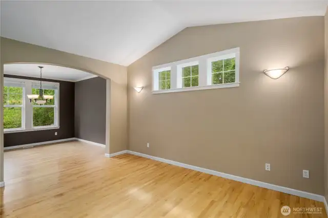 Living room is vaulted and offers transom windows allowing view of trees and extra light.
