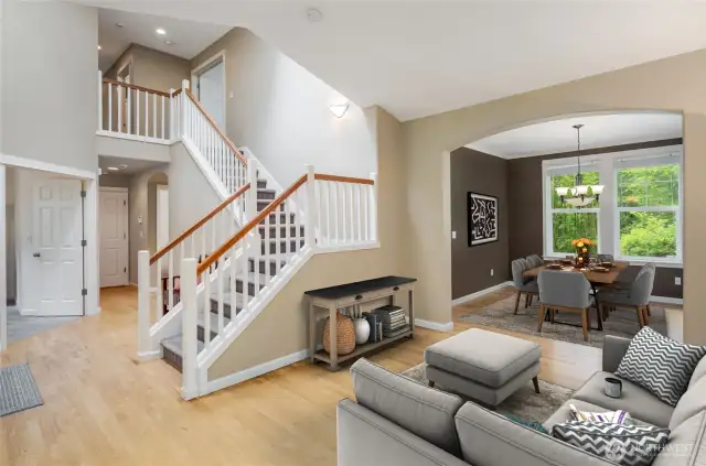 Virtually stages living room to foyer and dining room.