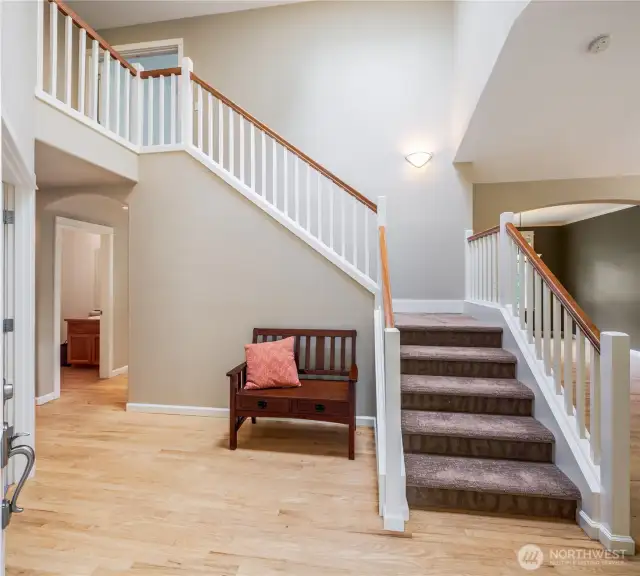 Hardwood floors flow through foyer into half bath and then kitchen with nook. Wide stairway to upper level.