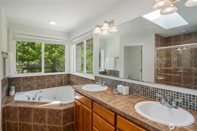 Corner tub with treed view.  Large vanity and double sinks.