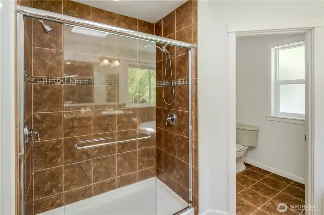 Walk-in shower with double heads. Note private toilet room.