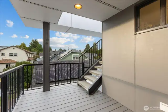 Large deck off of 3rd floor with stairs leading to rooftop deck