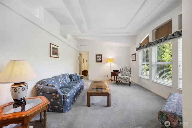 Welcoming space with carpet and entry to the Primary Suite.